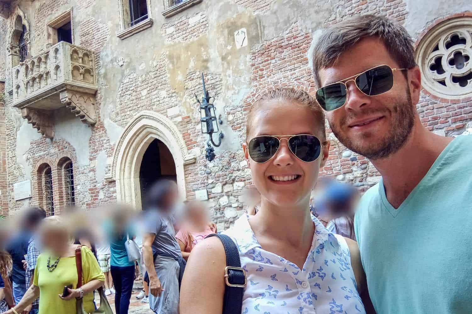 Michal and I by Juliet's balcony in Verona. A lot of people looking at it and taking pictures. The house and balcony are made of stone and look old.