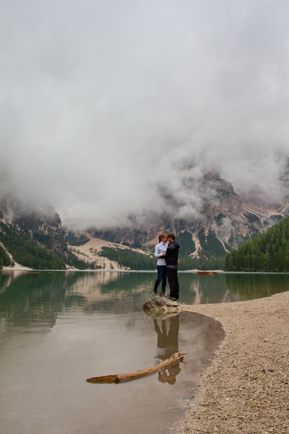 kristine and michal at lake braies in the dolomites with a cloud covering the mountains in the background