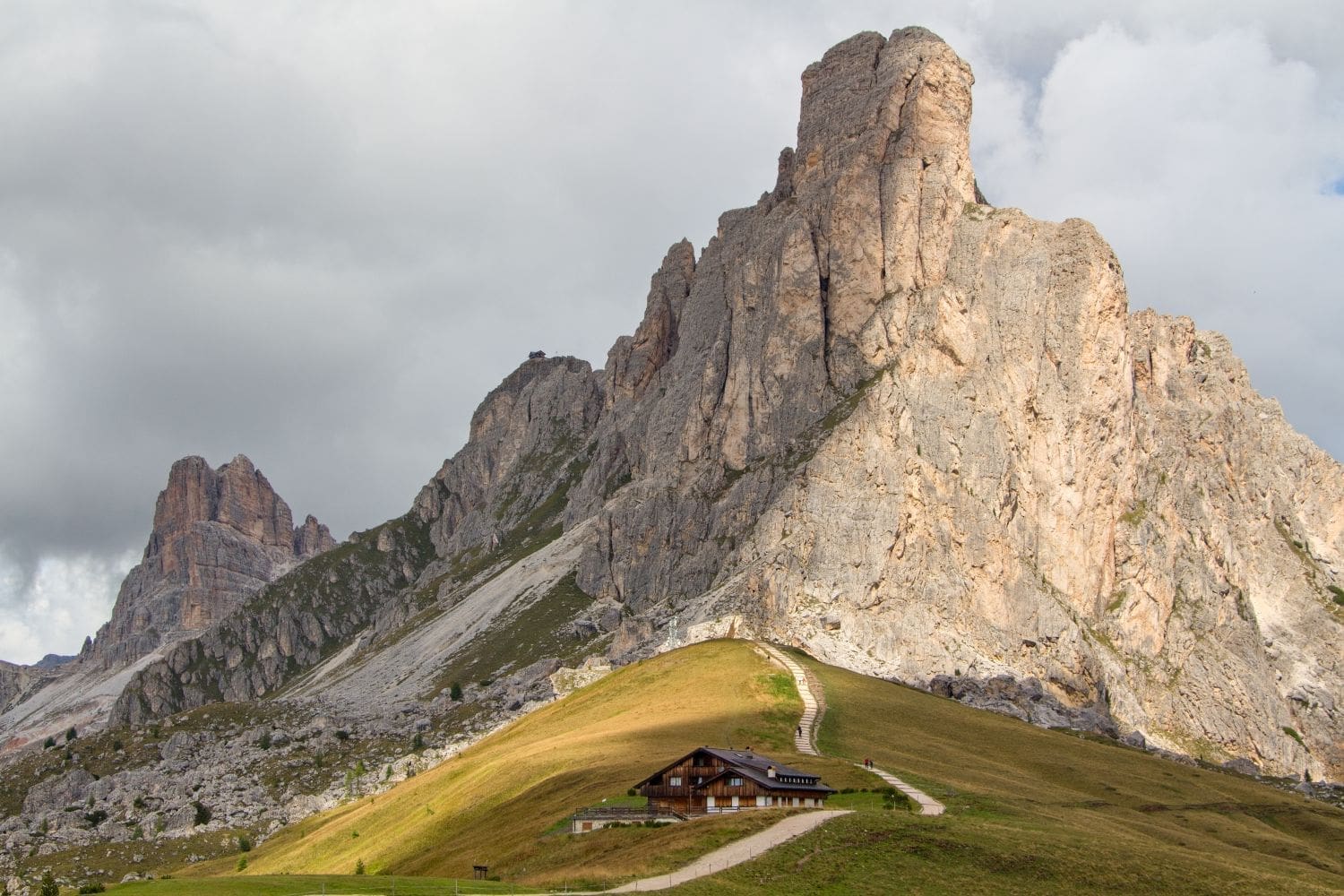 Passo Giau with the huge and impressive Ra Gusela cliff in the background and relatively tiny restaurant house in front of it