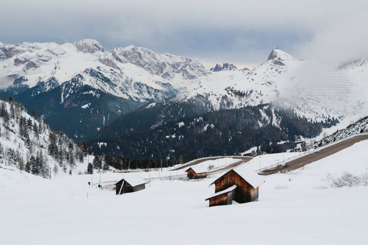 passo pordoi in the dolomites with snowy mountains and a winding road