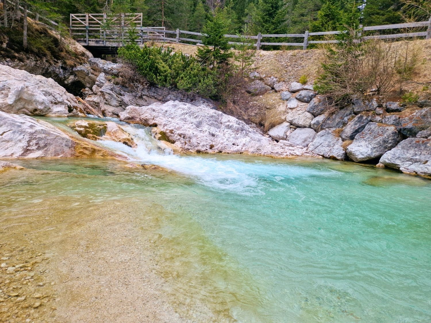 a small waterfall in the Dolomites with turquoise water flowing