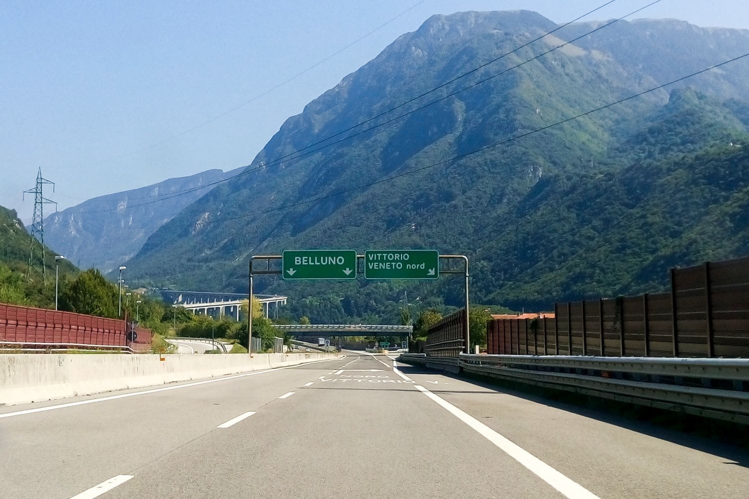 signs on italian highway showing that there will be an exit for vittorio veneto nord on the right side and the two straight lanes will go to belluno