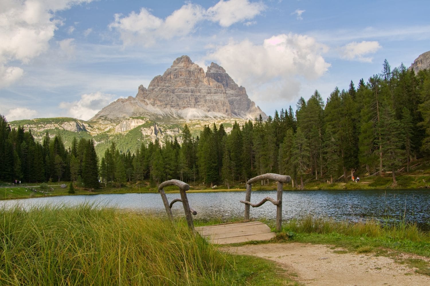 lake antorno in the dolomites with a triangular mountain in the background and a little bridge in the foreground