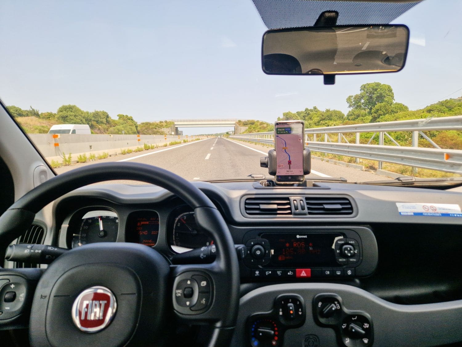 an empty motorway in sardinia photographed from the back seat of a car