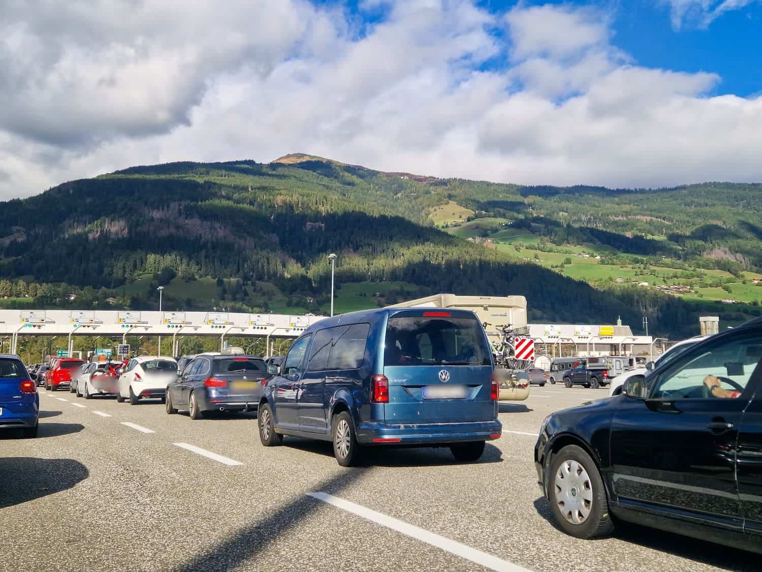 a lot of cars waiting in line at the tolls stations on a toll road in italy in the dolomites