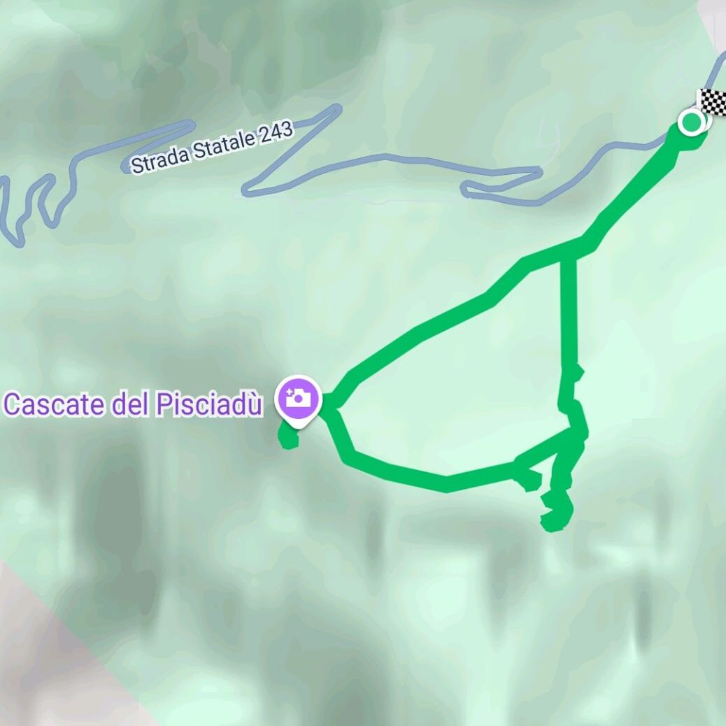 A map showing hiking trails near Cascate del Pisciadù in Italy. The green paths form loops near the waterfall, with a checkered finish point and Strada Statale 243 road visible at the top. Google watermark in the corner.